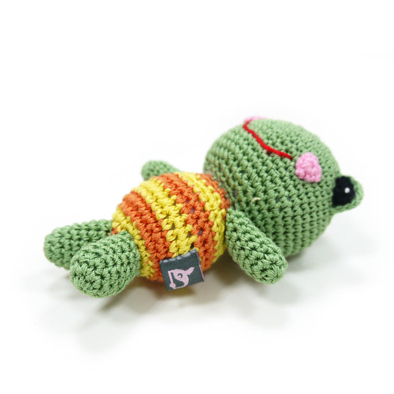 Crochet frog dog toy lying down, striped belly, red smile, black bead eyes, fabric tag
