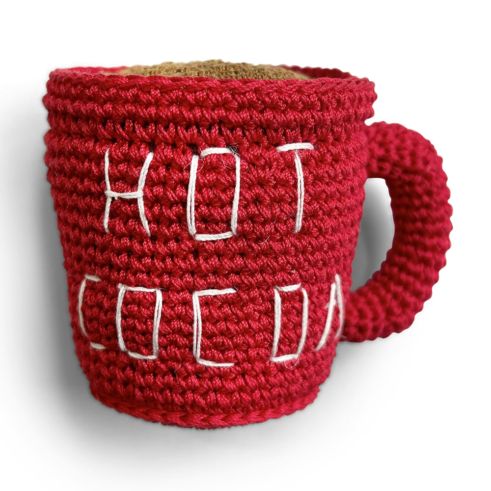 Red crochet hot cocoa mug dog toy with white stitched cocoa pattern and handle