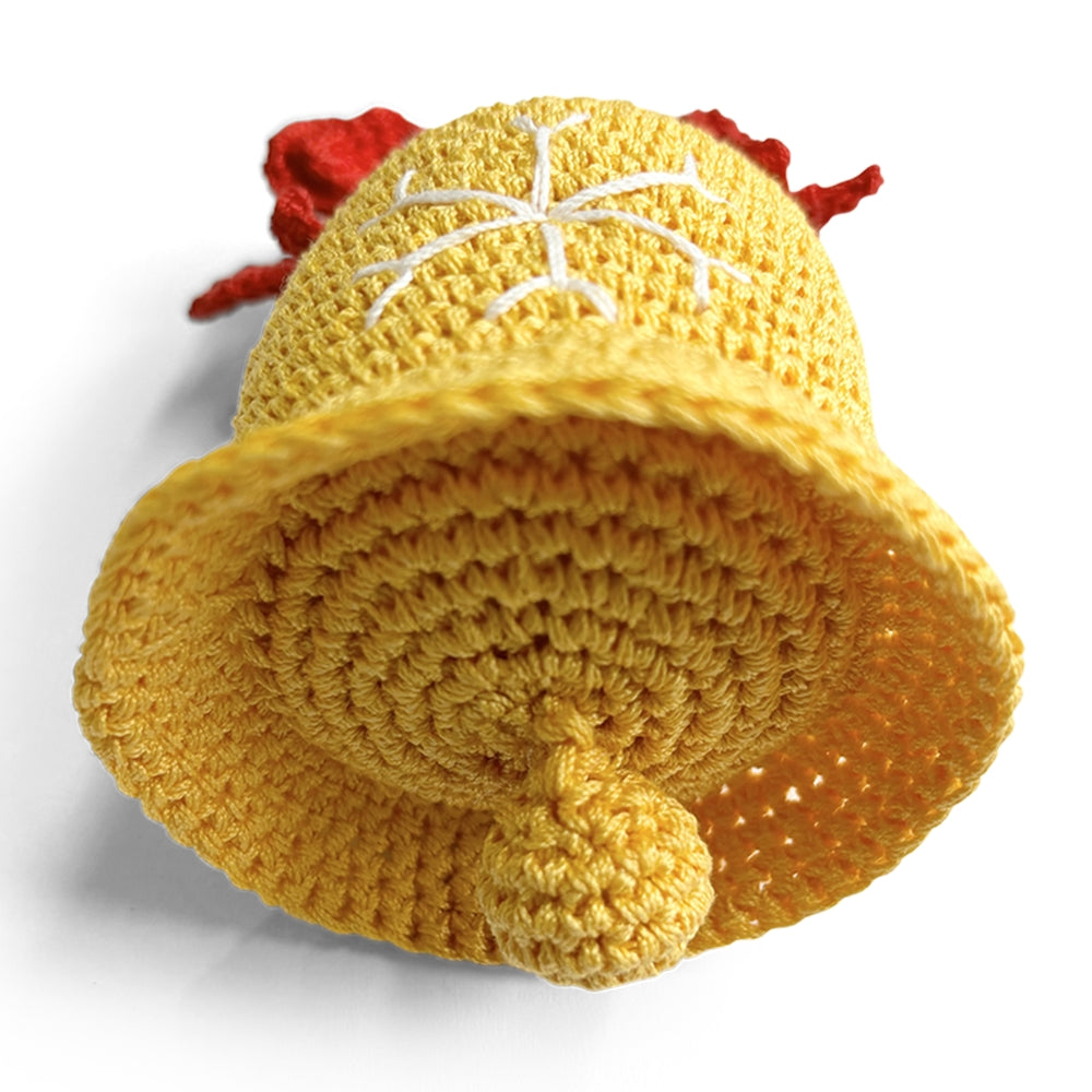 Crocheted dog toy bell with yellow body and curled bottom, red bow, and white snowflake