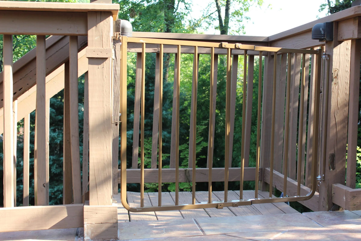Aluminum safety gate on outdoor deck with vertical bars and latch posts
