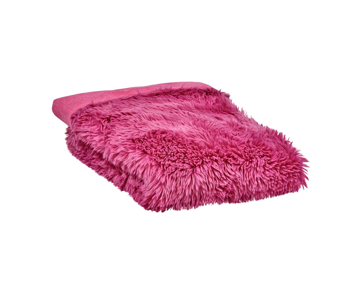 Reversible faux fur dog blanket in bright pink, folded with long shag texture edge
