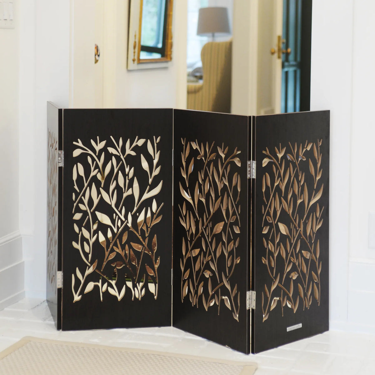 Freestanding 3-panel dog gate with gold leaf vine designs on black folding panels