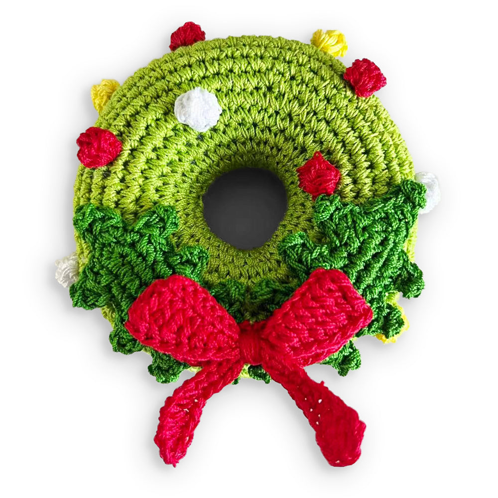 Crochet dog toy shaped as a green Christmas wreath with red bow and colorful accents