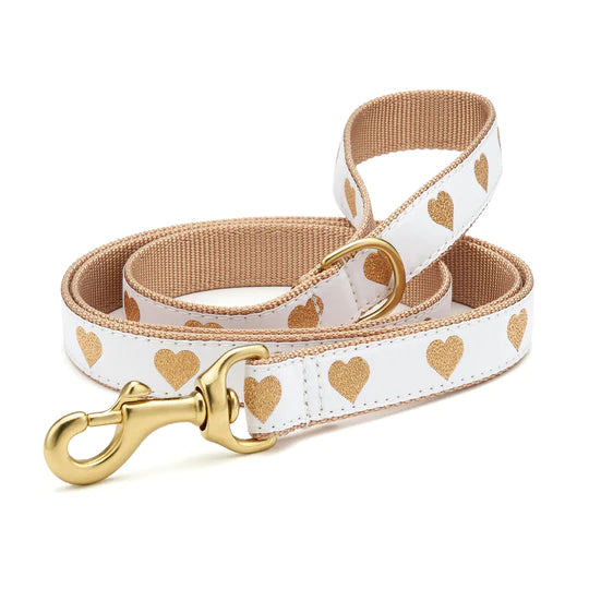 White dog collar with gold heart print and tan backing, plus matching leash with gold clasp