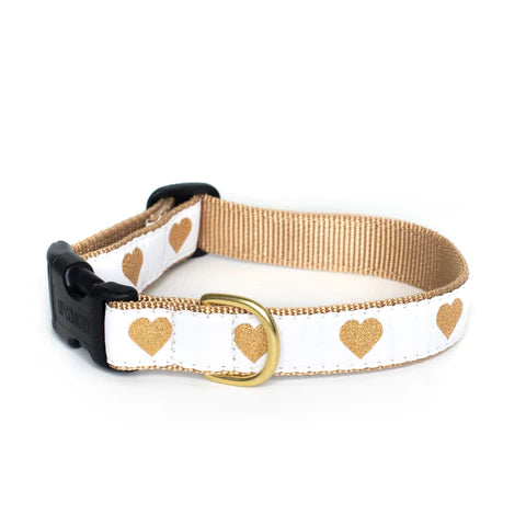 White dog collar with gold hearts, tan strap backing, gold D-ring, and black clasp