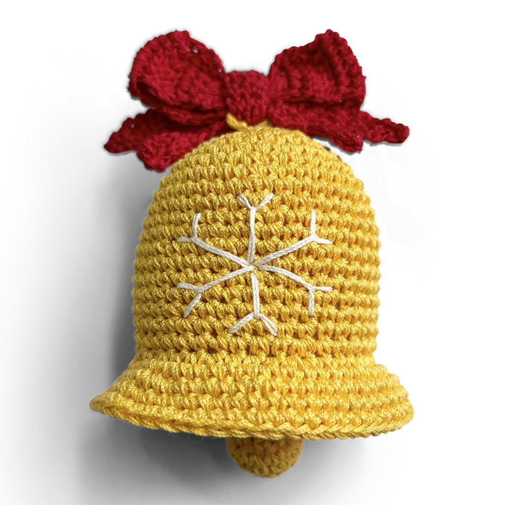 Crocheted dog toy bell with yellow body, red bow, and white snowflake stitches
