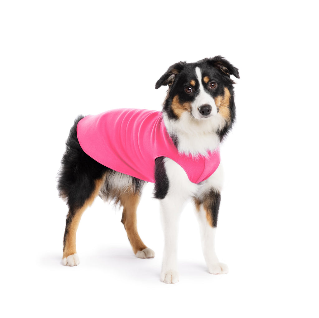 Hot pink stretch fleece dog coat with sleeveless design, worn by a black-and-brown dog