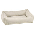 Light beige woven dog bed with rounded bolster sides and cushioned front