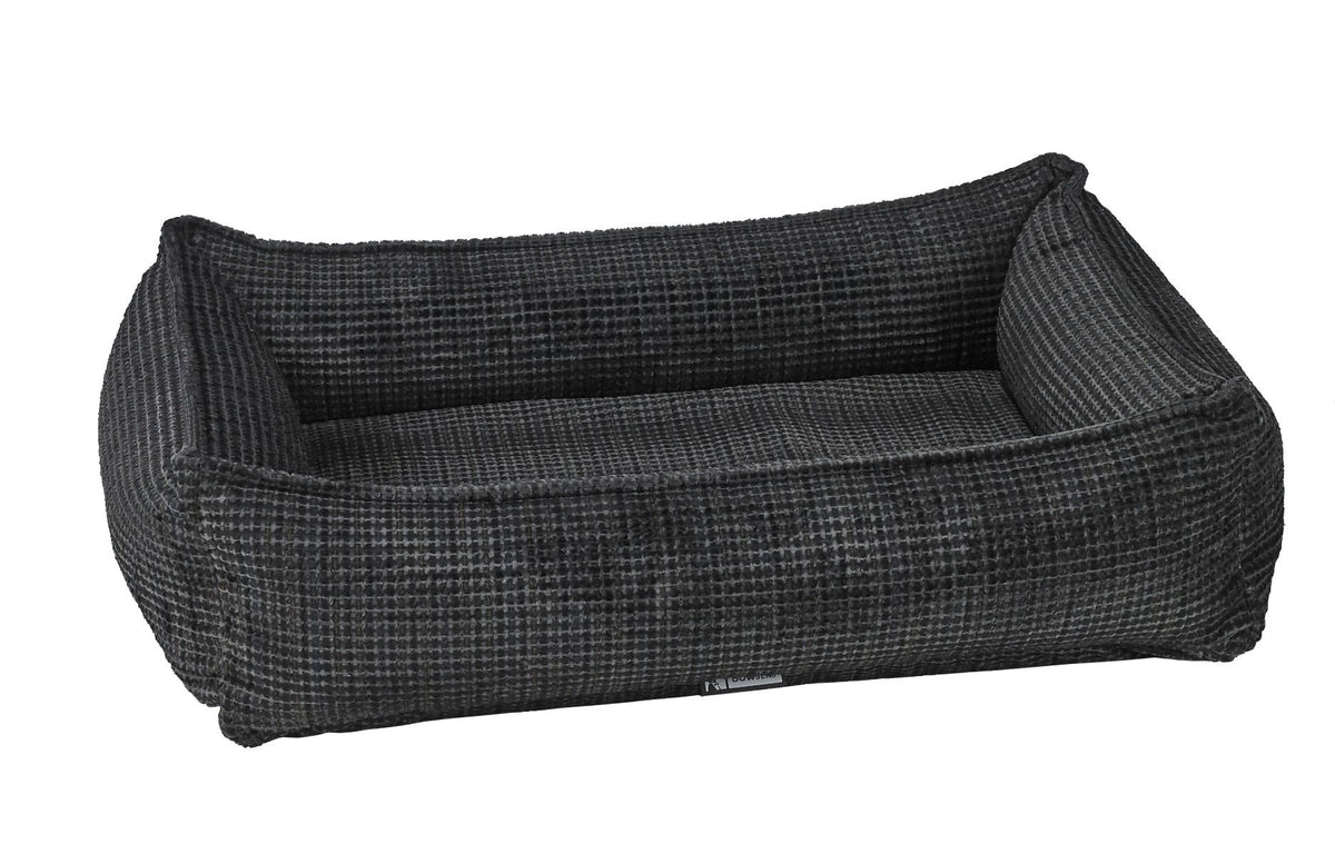 Dark gray woven dog bed with raised bolsters and rectangular cushion