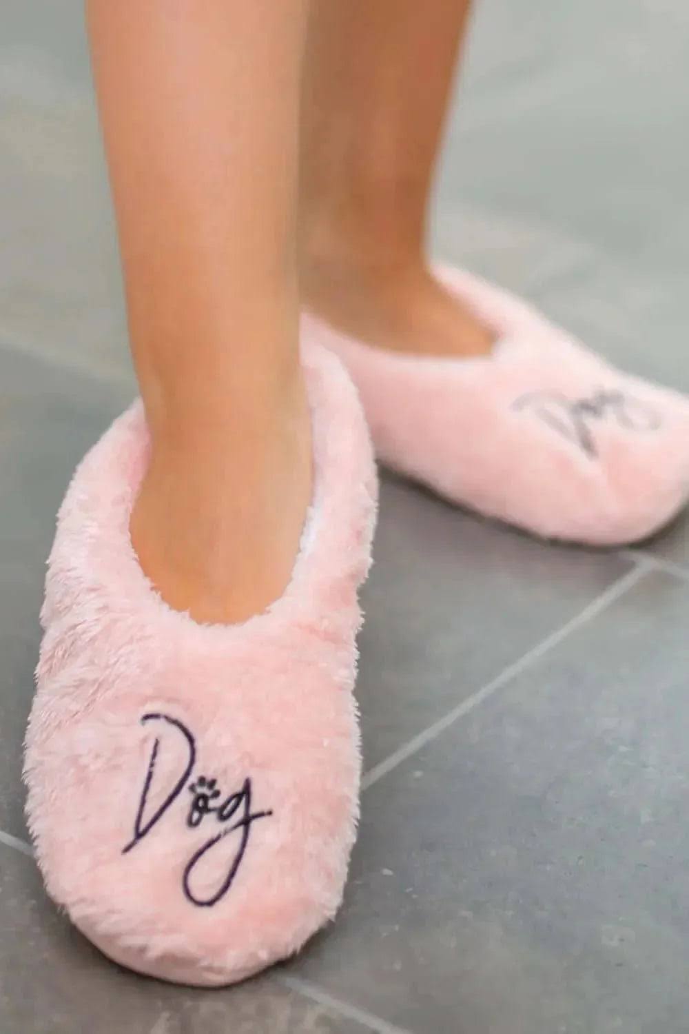 Pink fuzzy slip-on footsies slipper with embroidered 'Dog' logo on the toe