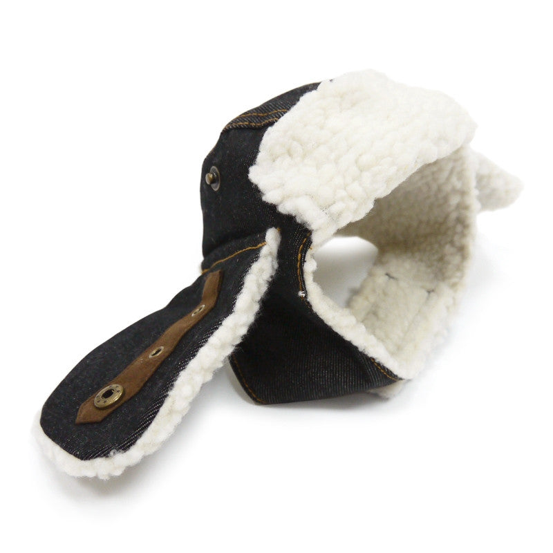 Black dog trapper hat with white fleece lining and chin strap, brown leather tabs