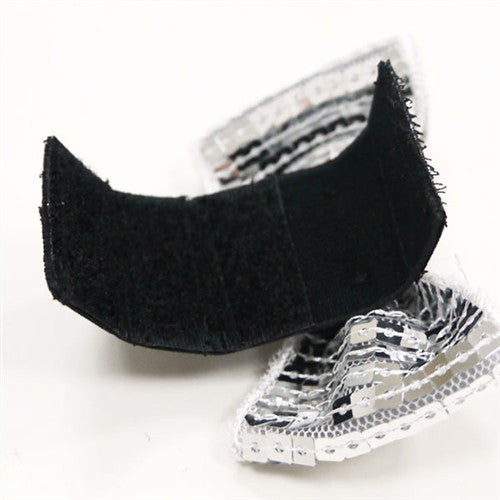 Silver sequin dog bow tie with black fabric backing visible beneath the bow