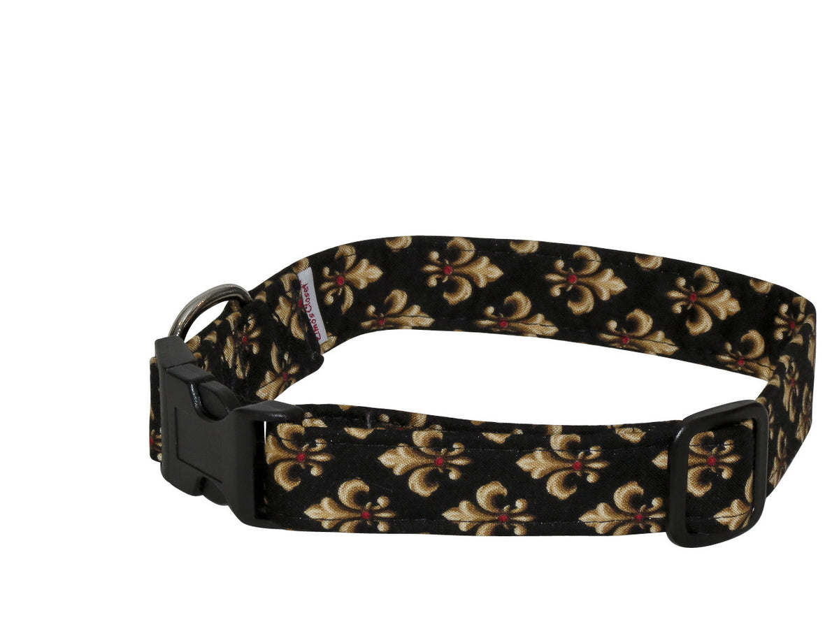 Fleur de lis dog collar with black base and gold floral pattern, plastic buckle closure