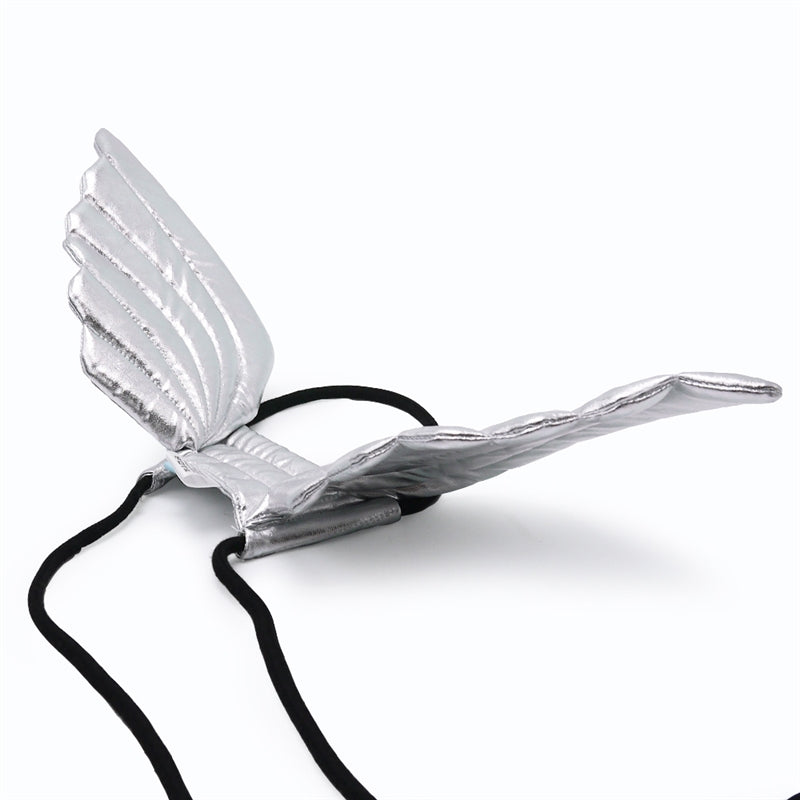 Metallic silver angel wings with black straps and loop fasteners, close-up