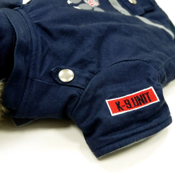Dark blue dog jacket sleeve with snap button and X-9 UNIT patch label