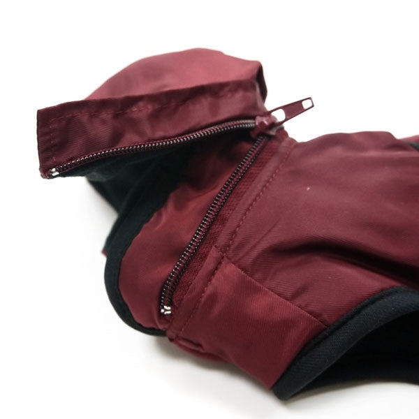 Maroon dog trench coat zipper detail with black trim edge, close-up view