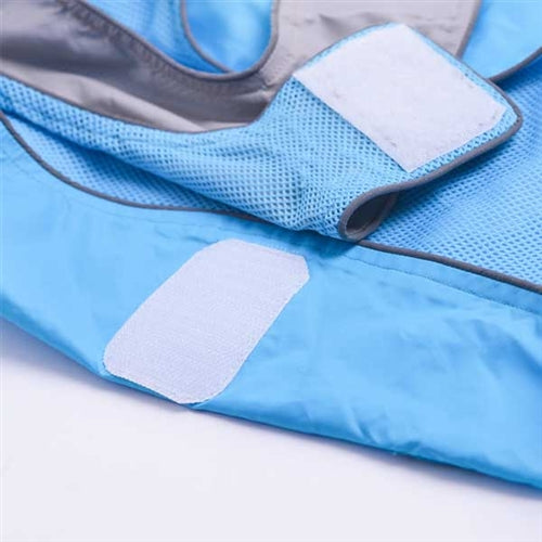Close-up of light-blue dog raincoat fabric with gray patch panels and stitching