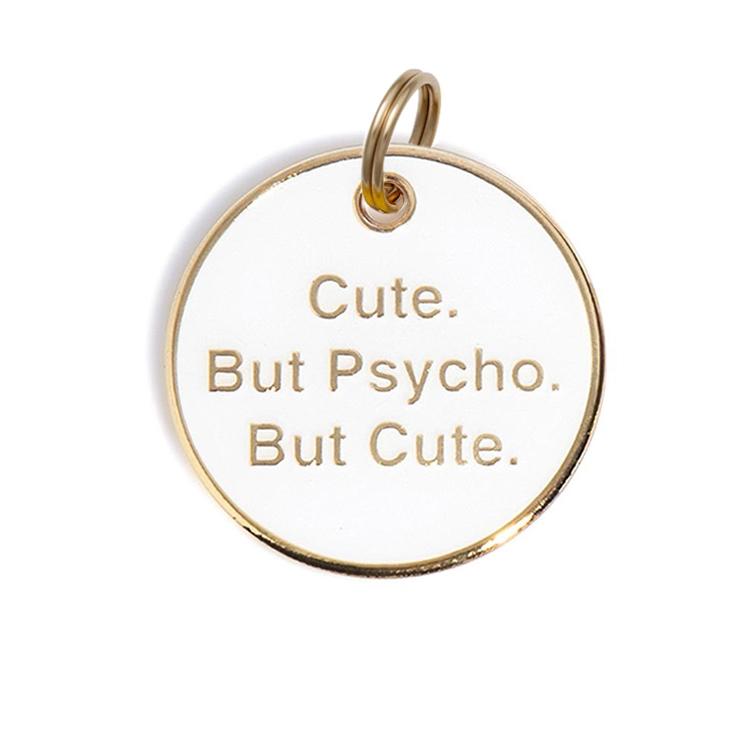 Round gold dog tag with "Cute. But Psycho. But Cute." and gold key ring loop