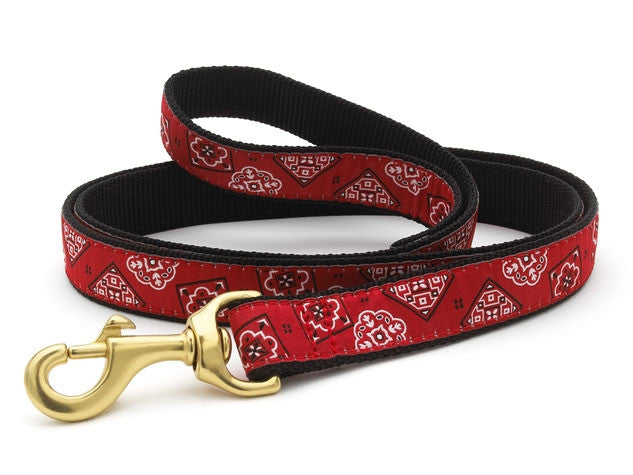 Red bandana-pattern dog collar with gold-tone hardware, lying flat