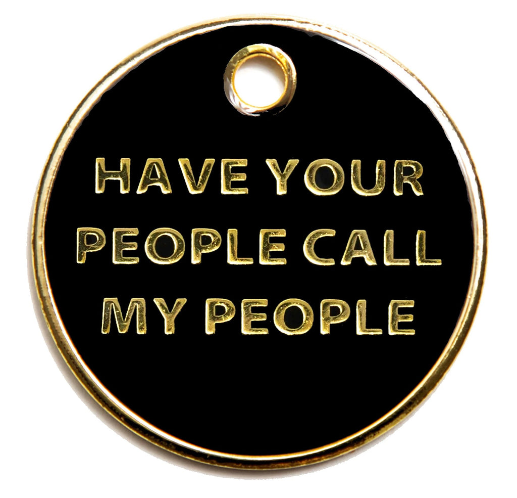 Round black dog I.D. tag with gold border and text: HAVE YOUR PEOPLE CALL