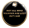 Black round dog ID tag with gold engraved text and metal hanging ring at top