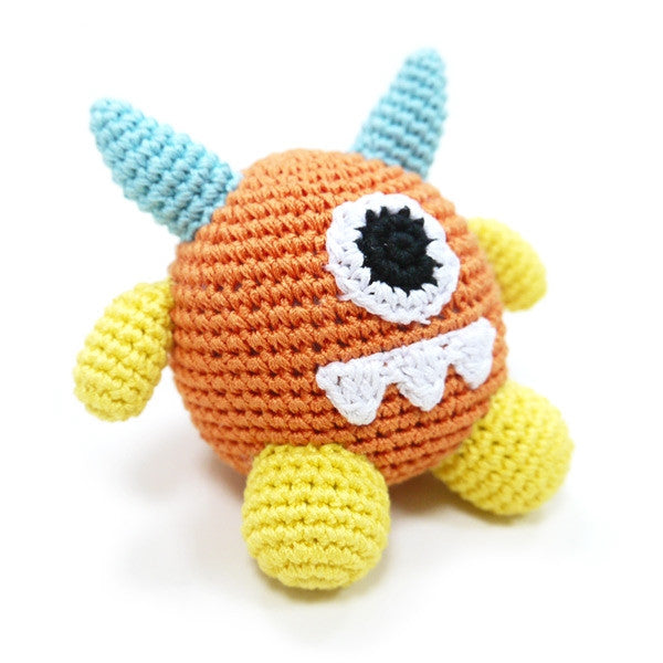 Crocheted monster dog toy with squeaker, orange face with black eye patch and white tooth detail