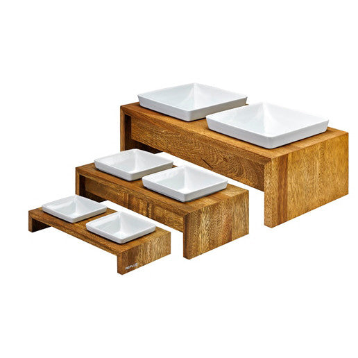 Natural bamboo dog feeder with four white square bowls on raised steps and tiers.