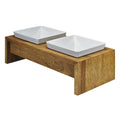 Natural bamboo dog feeder with two white square bowls on a raised wooden stand.