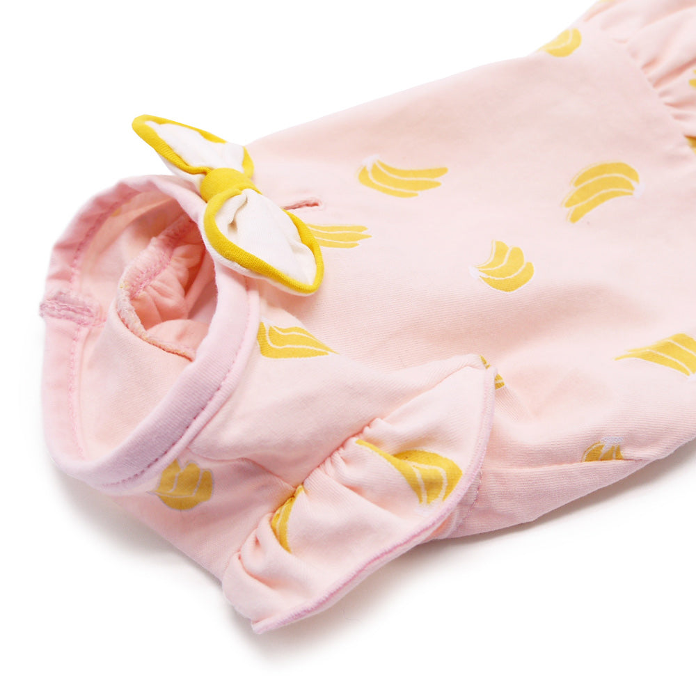 Pink banana-print dog dress close-up of bow and gathered hem