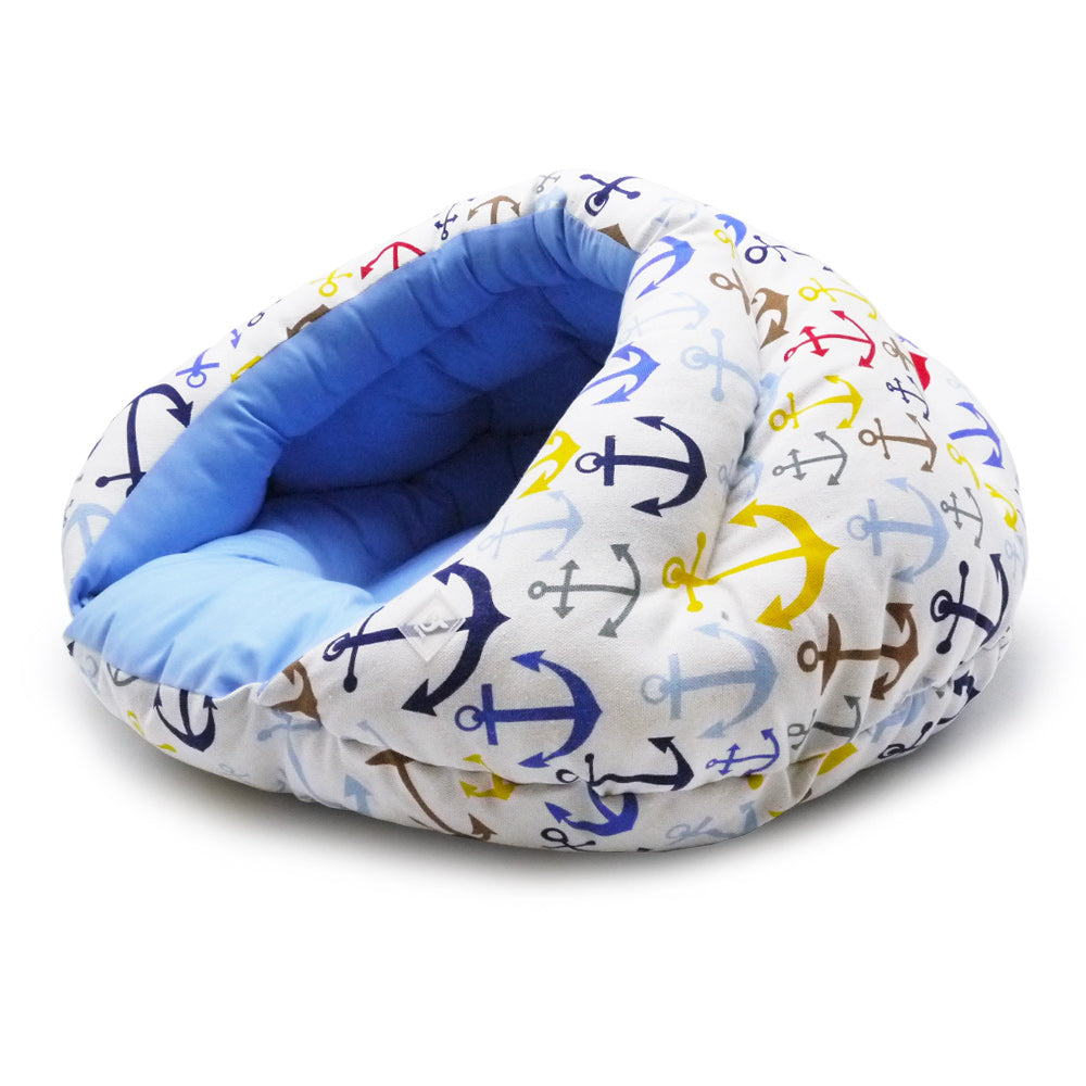 Cushioned small dog bed with blue anchor fabric outer and light blue interior bolster