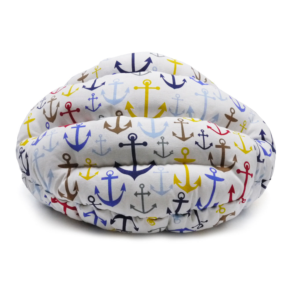 Small dog snuggle bed with white anchor pattern outer shell and blue inner lining