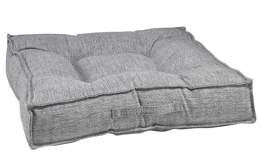 Rectangular gray cushioned dog bed with raised rim and tufted bolster