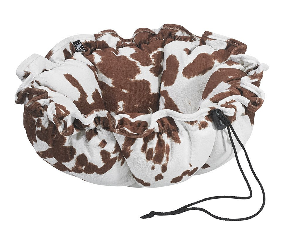Brown-and-white cowprint pet bed with plush trim and tied drawstring