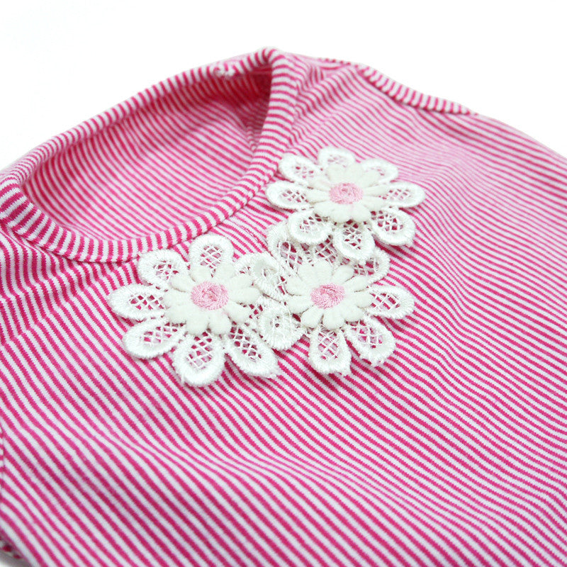 Close-up of pink striped dog dress with white eyelet flower applique on front panel