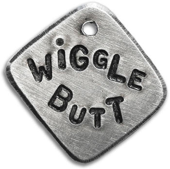 Stamped metal dog tag reading "WIGGLE BUTT" with paw and bone icons