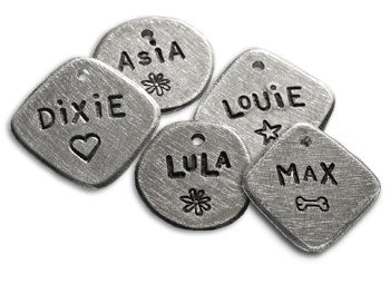 Hand-stamped round dog ID tags with engraved names, hearts, and symbols, aluminum