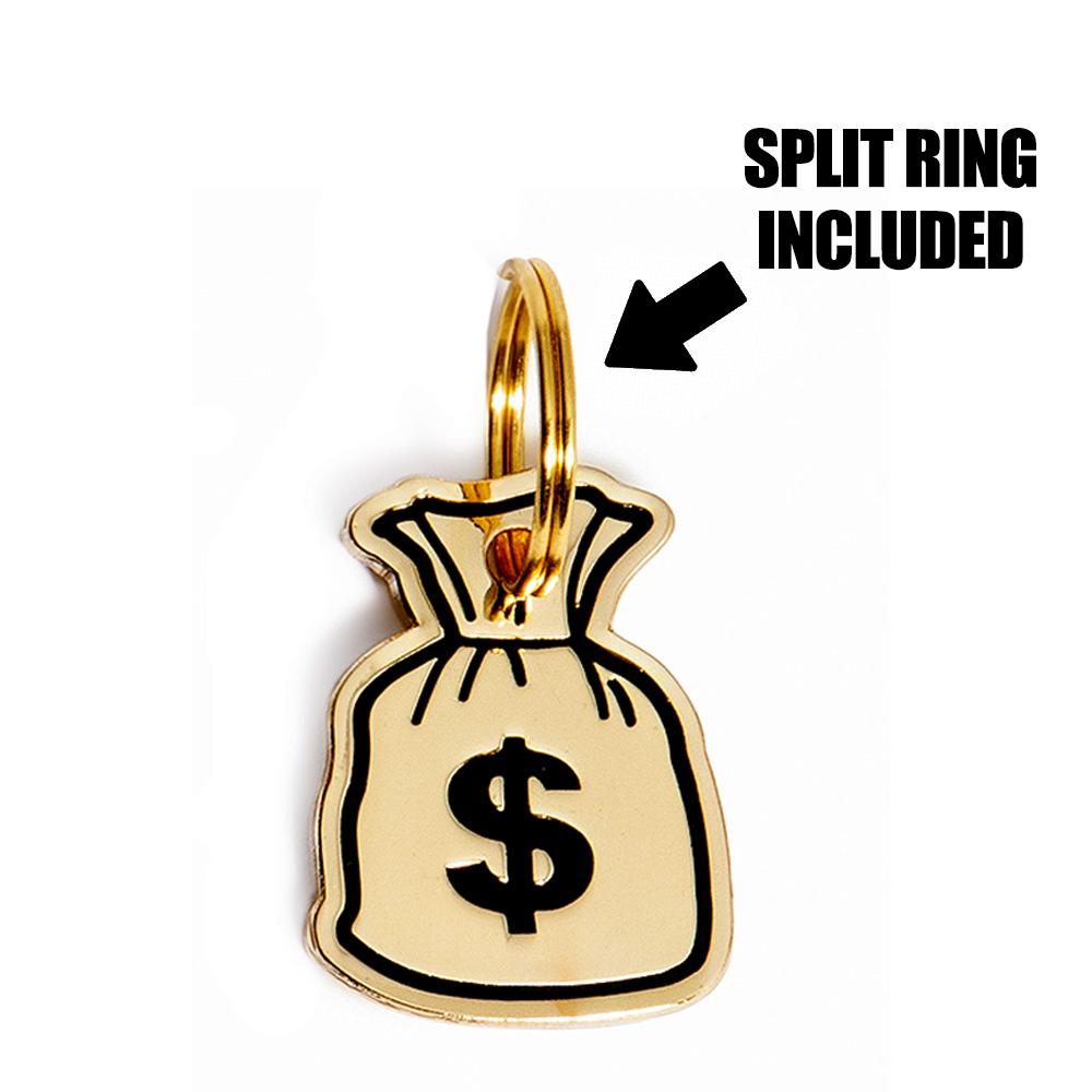 Gold-tone money bag dog tag charm with black dollar sign and top loop.