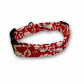 Red dog collar with white floral and leaf print, black edge trim, metal buckle ring