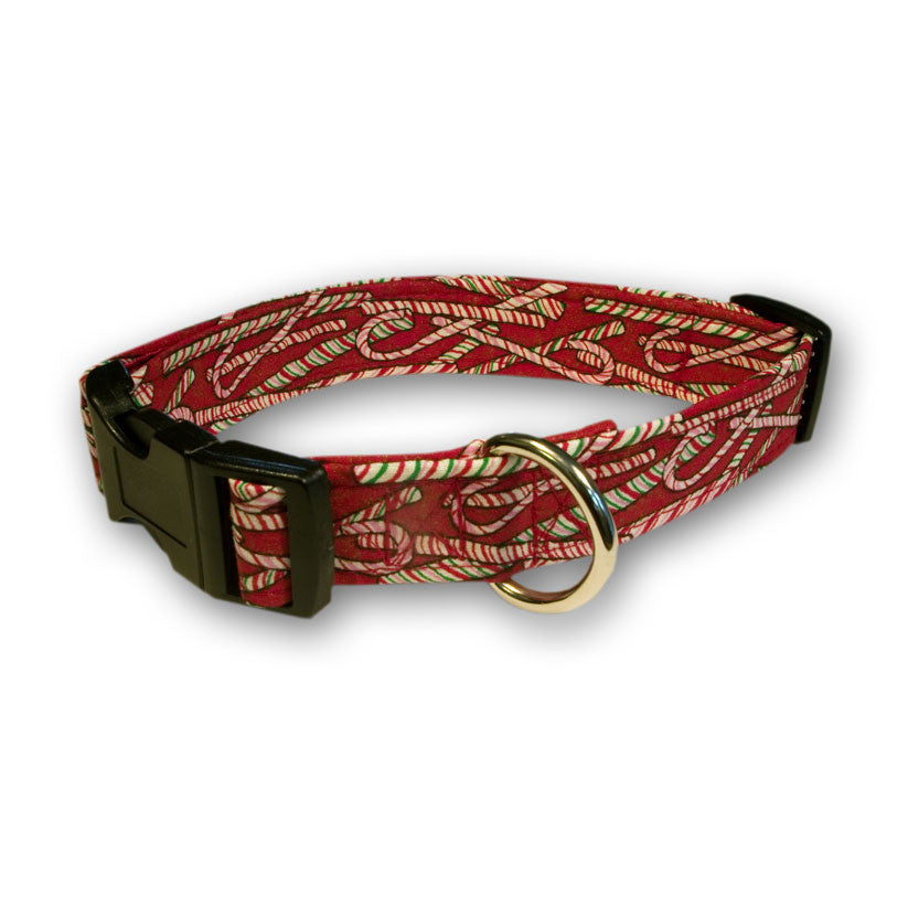Red patterned dog collar with green-and-white peppermint design, black buckle, metal D-ring