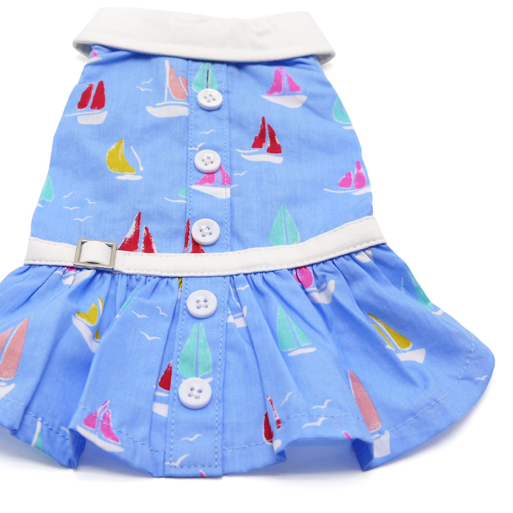 Blue sailboat print dog dress with white trim, button placket, and wide gathered hem