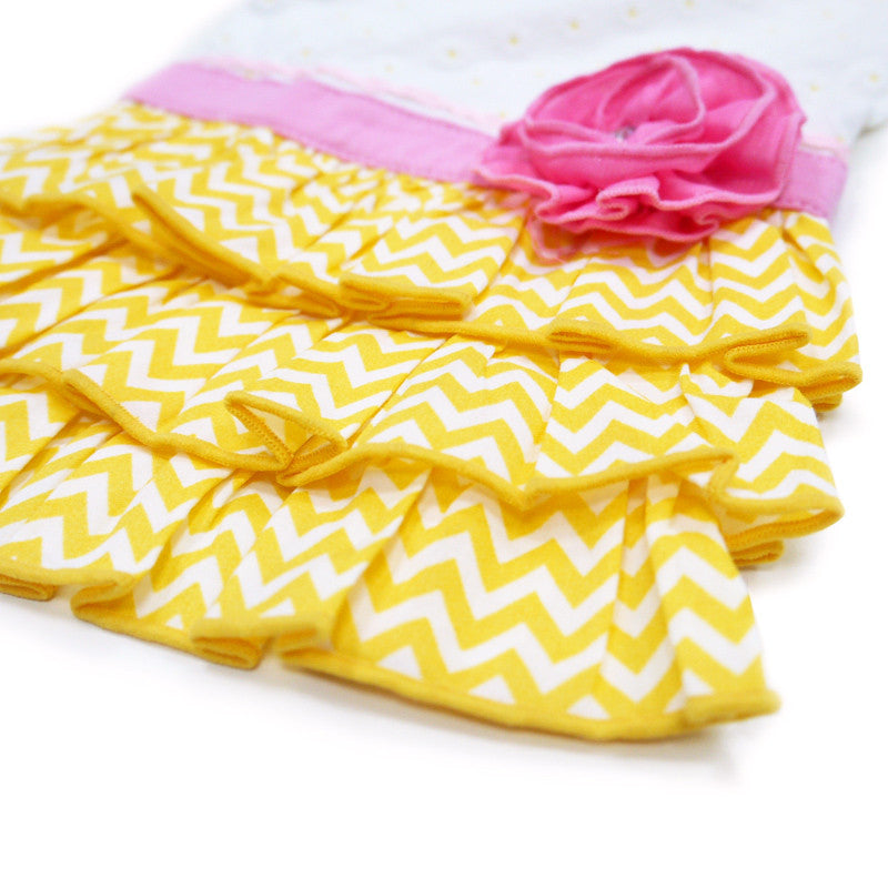Dog dress skirt close-up: layered yellow chevron ruffles with pink rose at waistband