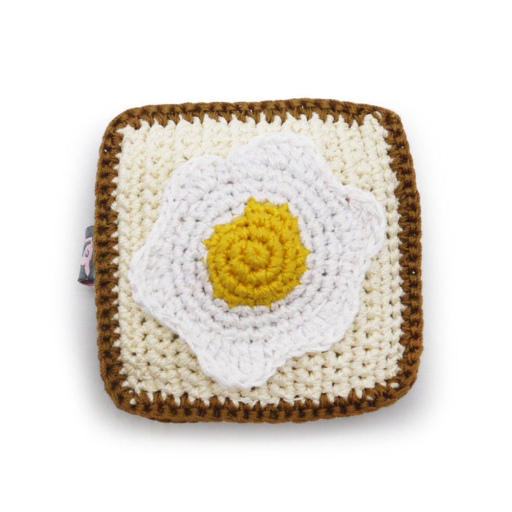 Crochet egg-shaped dog toy with squeaker, square pouch, white and yellow yolk design