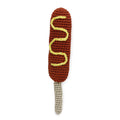 Crocheted brown hot dog dog toy with yellow wavy stripes and light gray yarn end