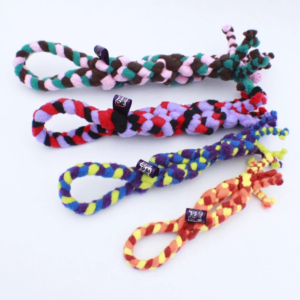 Striped fleece tug toys with knot centers, loop ends, and small plush accents