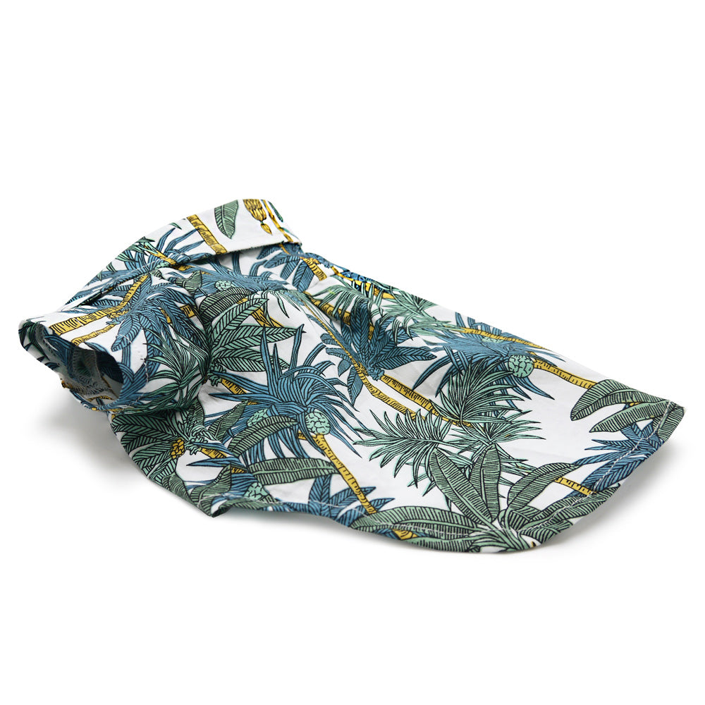 Flat lay of tropical leaf dog shirt, white with blue, green, and yellow accents
