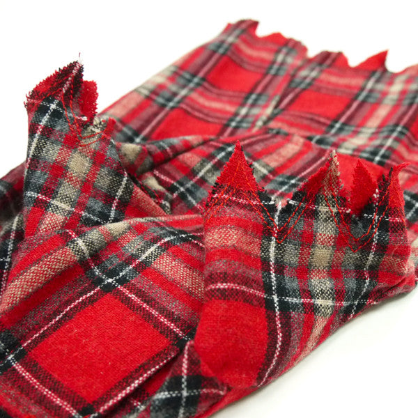 Red, black and gray plaid dog costume fabric with textured hem and fringed edge.